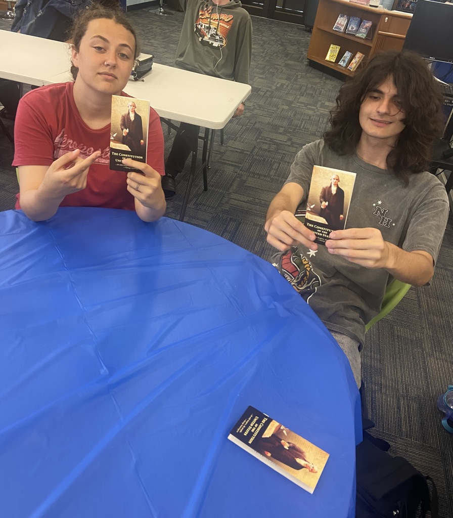 Students seated and listening attentively to a Constitution Week presentation in the media center.