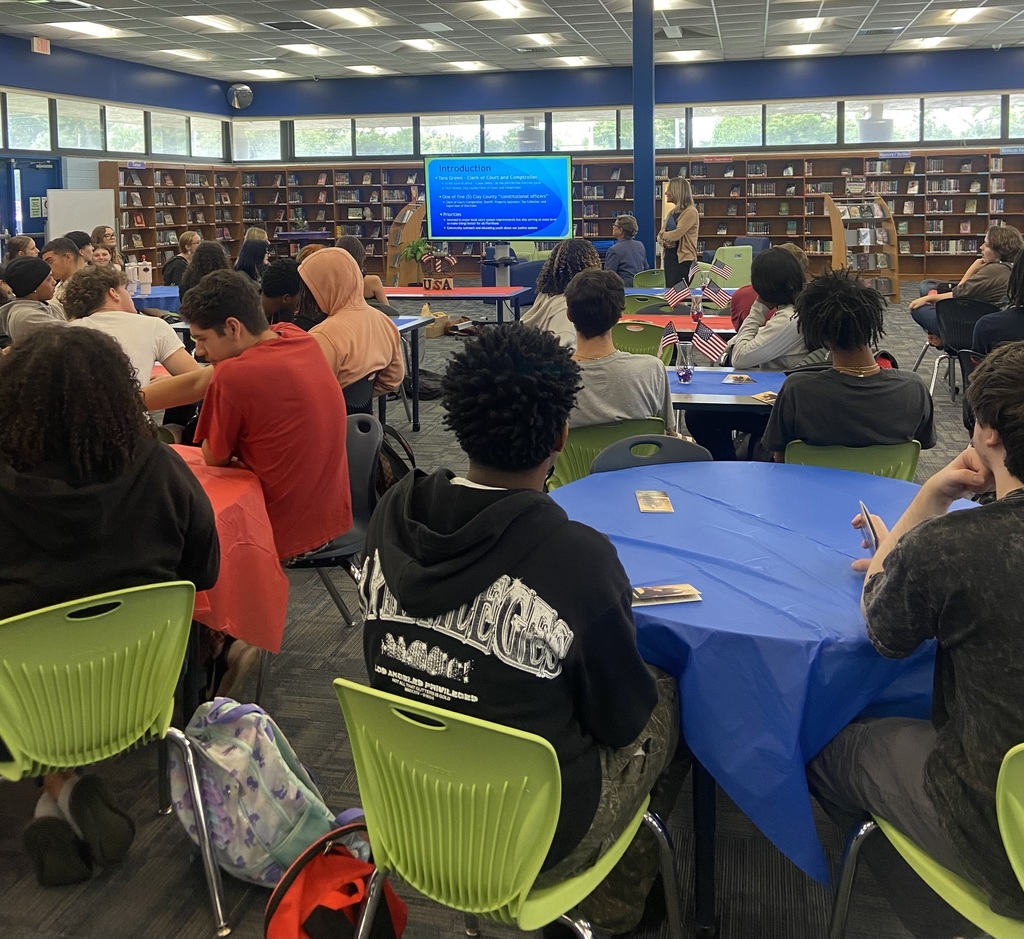 Students seated and listening attentively to a Constitution Week presentation in the media center.