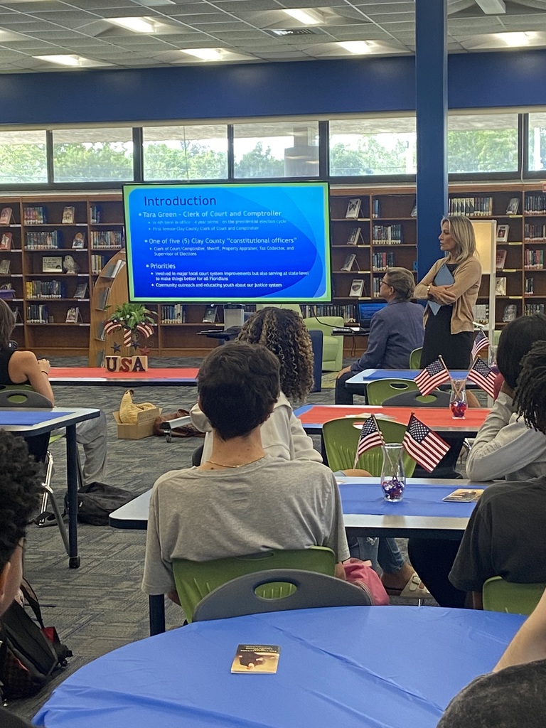 Students seated and listening attentively to a Constitution Week presentation in the media center.