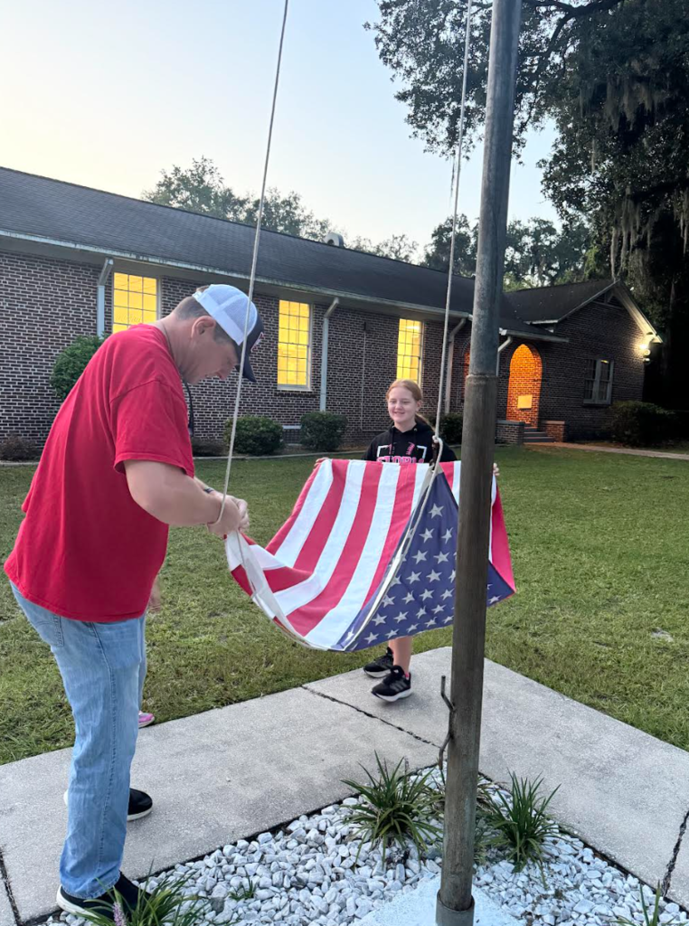 Dad helping daughter raise the flag 
