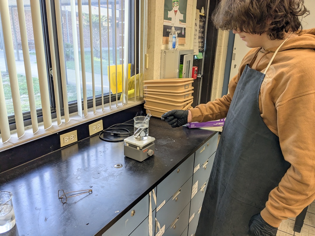 A burning splint test being performed over a test tube to confirm the production of oxygen gas in AP/IB Chemistry