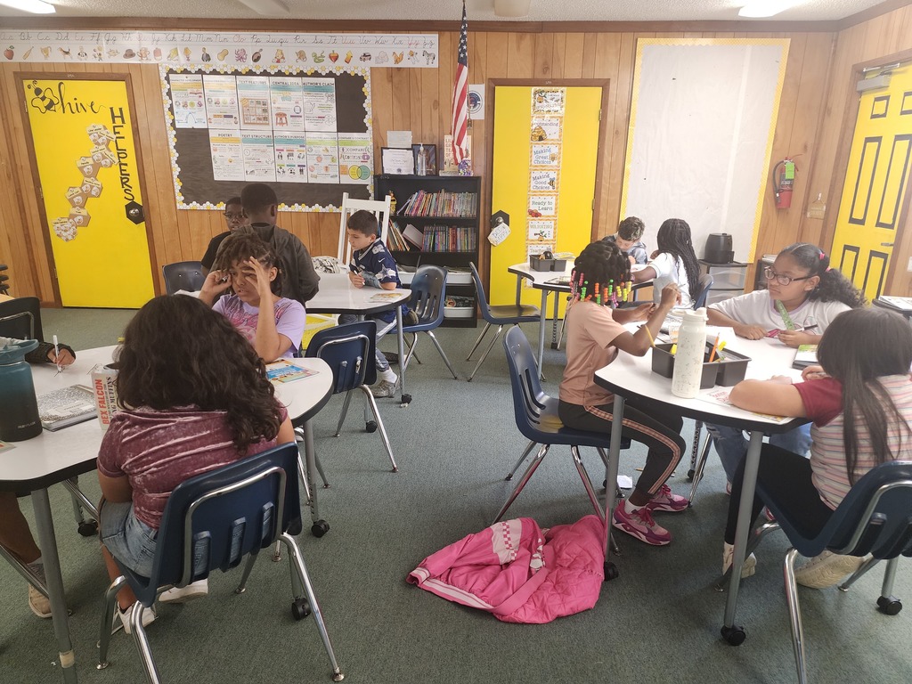 3rd grade classroom with students working together to analyze the plot of a story