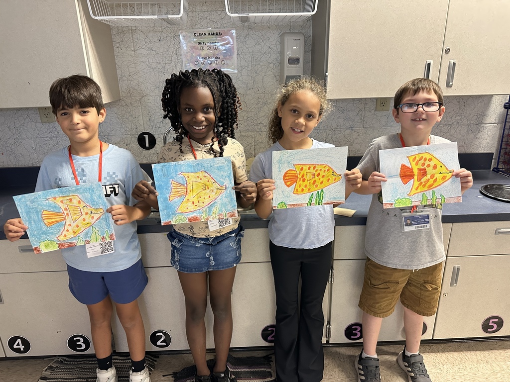 second grade students with fish drawings