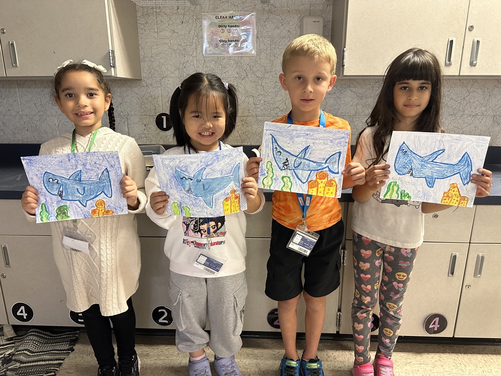 first grade students with shark drawings
