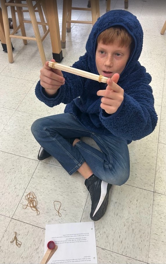 6th grade and Kindergarten have both been working on Force and Motion this quarter. Today they paired up in our Science Lab to use catapults, built by 6th graders, to launch cotton balls at targets with our K friends….It was awesome!