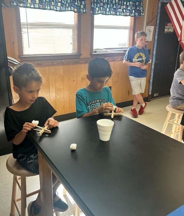 6th grade and Kindergarten have both been working on Force and Motion this quarter. Today they paired up in our Science Lab to use catapults, built by 6th graders, to launch cotton balls at targets with our K friends….It was awesome!