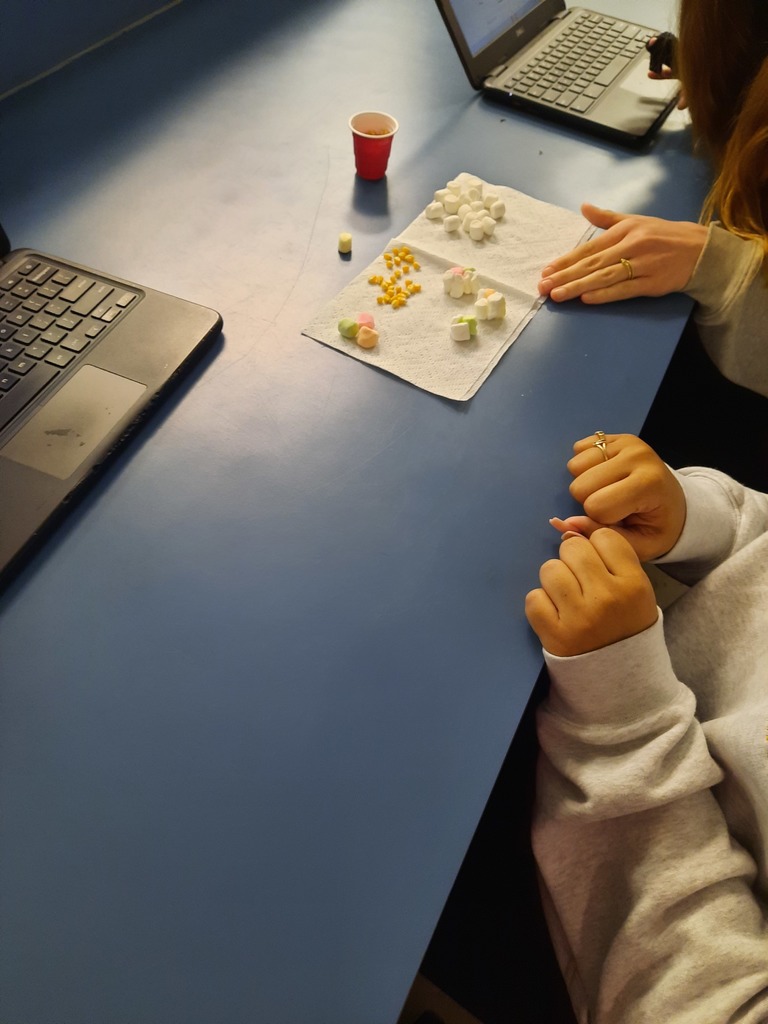 Ms. Klaes’s Astronomy students explored nuclear fusion this week through a hands-on proton–proton chain lab. Students modeled the type of fusion that powers our Sun and other medium- to low-mass stars, deepening their understanding of how energy is created in stellar cores. Using white marshmallows to represent protons, colorful marshmallows to represent neutrons, and popcorn kernels to convey the energy released during the reaction, students worked through each step of the fusion process. This interactive lab helped turn a complex concept into something students could see, build, and explain, connecting classroom learning to real astrophysical phenomena.