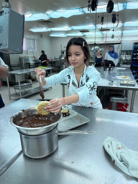 Culinary students in 3 and 4 took on a sweet, multi-day project, crafting homemade ice cream sandwiches from start to finish. On day one, students prepared their ice cream base and mise-en-place for their cookies. Day two focused on churning the ice cream, freezing it on sheet pans, and baking fresh cookies. On the final day, students used cookie cutters to shape the ice cream, assembled their sandwiches, and finished them off with a chocolate dip, bringing creativity, precision, and delicious results together.