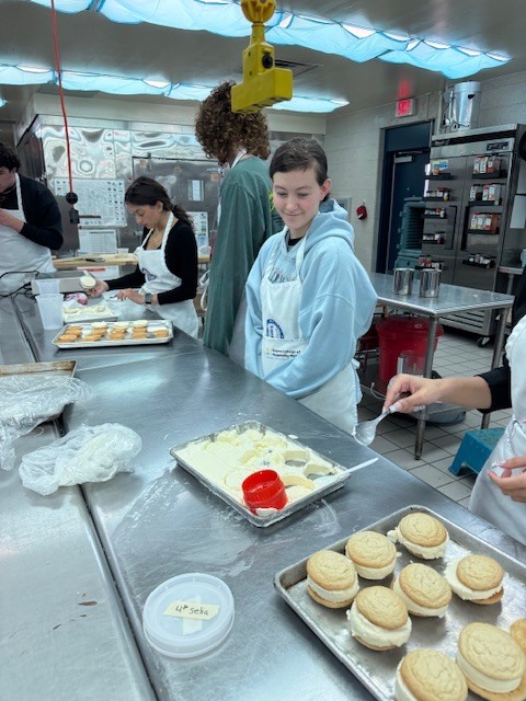 Culinary students in 3 and 4 took on a sweet, multi-day project, crafting homemade ice cream sandwiches from start to finish. On day one, students prepared their ice cream base and mise-en-place for their cookies. Day two focused on churning the ice cream, freezing it on sheet pans, and baking fresh cookies. On the final day, students used cookie cutters to shape the ice cream, assembled their sandwiches, and finished them off with a chocolate dip, bringing creativity, precision, and delicious results together.