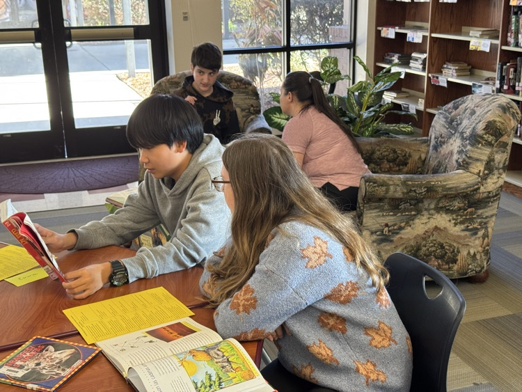 student reading a text to a peer.