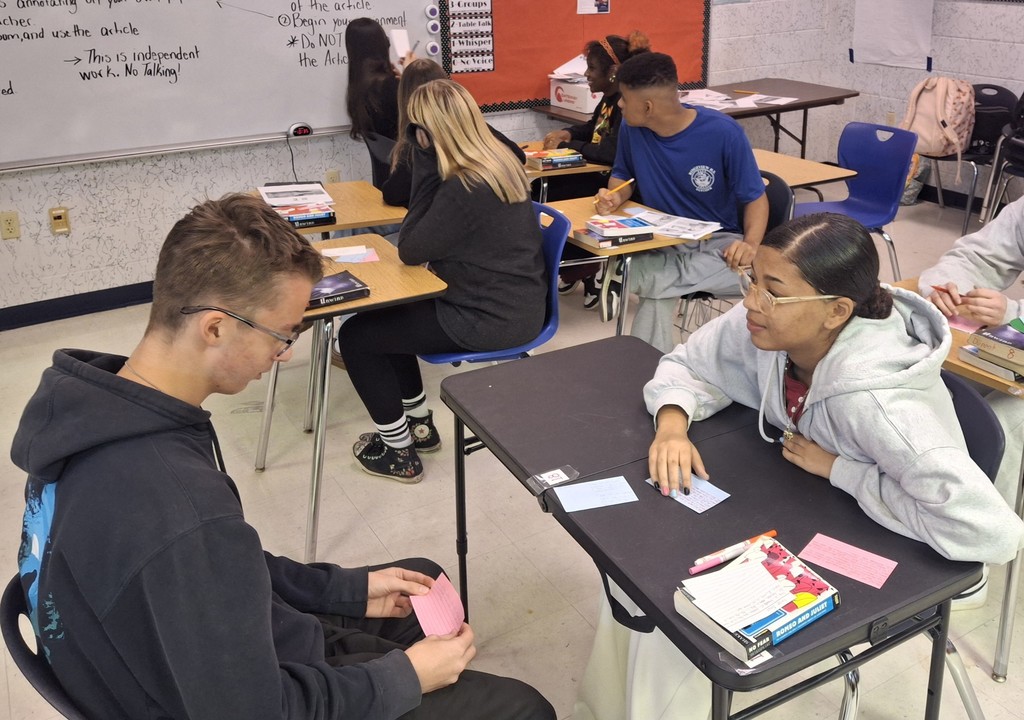 Students in Ms. Dupont’s 9th-grade English class recently brought Romeo and Juliet to life through thoughtful discussion and debate. As they prepared to write their argumentative essays, students began by creating their own personal definitions of love before gathering textual evidence to support two perspectives: whether Romeo and Juliet shared true love or their relationship was not authentic. Using color-coded index cards, students recorded quotes and explanations for both sides, then worked with a partner to debate the strength of each argument. After reaching a consensus, pairs selected a quote and explanation to display on poster paper for their classmates to review. This engaging activity helped students strengthen their critical thinking, collaboration, and evidence-based writing skills.