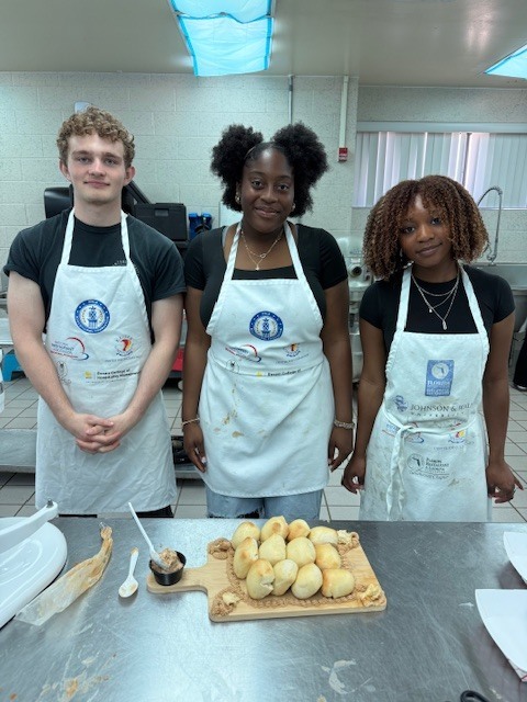 Our Culinary 3 and 4 students recently took on the challenge of creating their own bread-and-butter boards from scratch! Students began by researching a bread recipe that could be completed within two days. On day one, they prepared the dough and placed it in the refrigerator to slow the rise. On day two, they shaped and baked their loaves, then created a flavored butter of their choice. From sweet to savory, the variety of butters paired perfectly with the freshly baked bread. To finish, students arranged their creations on wooden cutting boards for a beautiful presentation. It was a hands-on lesson in patience, technique, and creativity, and the results were delicious! 