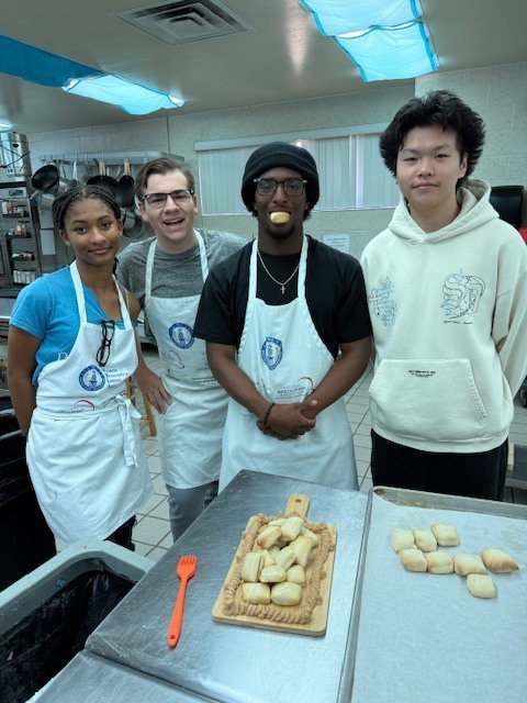 Our Culinary 3 and 4 students recently took on the challenge of creating their own bread-and-butter boards from scratch! Students began by researching a bread recipe that could be completed within two days. On day one, they prepared the dough and placed it in the refrigerator to slow the rise. On day two, they shaped and baked their loaves, then created a flavored butter of their choice. From sweet to savory, the variety of butters paired perfectly with the freshly baked bread. To finish, students arranged their creations on wooden cutting boards for a beautiful presentation. It was a hands-on lesson in patience, technique, and creativity, and the results were delicious! 