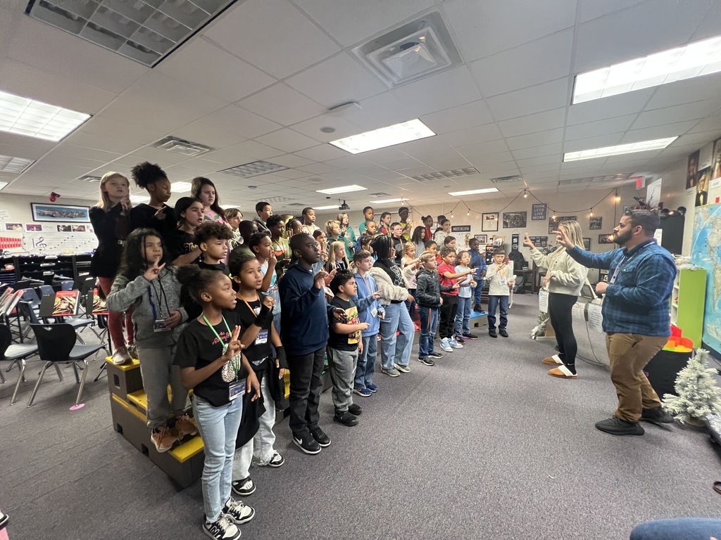 students singing and signing under the direction of Mr. Rivera and Mrs. McClure