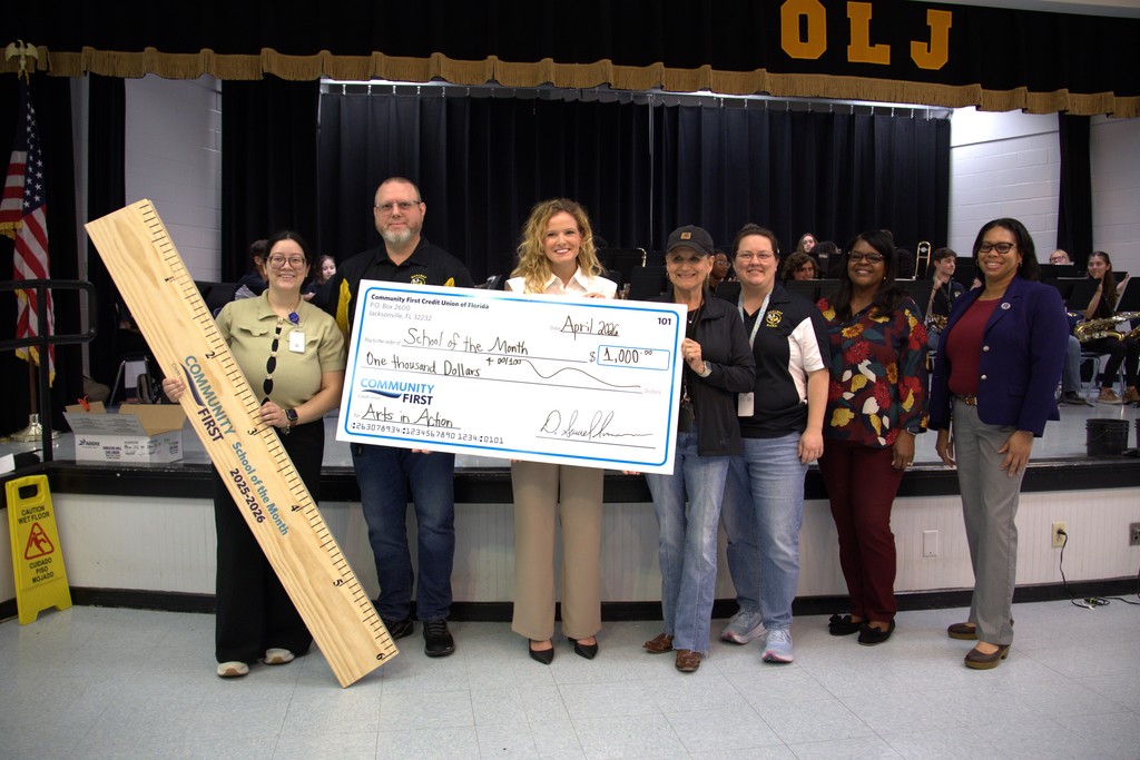 Oakleaf Junior Admin and teachers holding check from community first