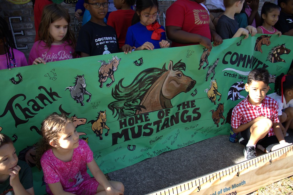 Students holding a Home of the Mustangs Banner