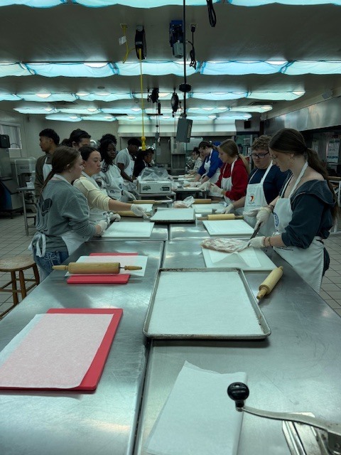 Recently, our Culinary students worked hard to prepare an incredible meal for the Clay Can Dance event. Students pounded out 250 pieces of chicken, and Mrs. Stevens’ 3rd period was a tremendous help during the preparation process while many students were away at Grad Bash.  The menu featured rolled chicken stuffed with spinach and Boursin cheese, Caprese skewers, salad, green beans, meatballs, bruschetta, molded butter, and mashed potatoes. A special thank you goes to Angelica, Mariah, and Sidney, who came in on Saturday to help finish the meal and prepare the mashed potatoes for pick up.  We are proud of the teamwork, dedication, and talent our students demonstrated, and we are so glad the guests enjoyed the meal.