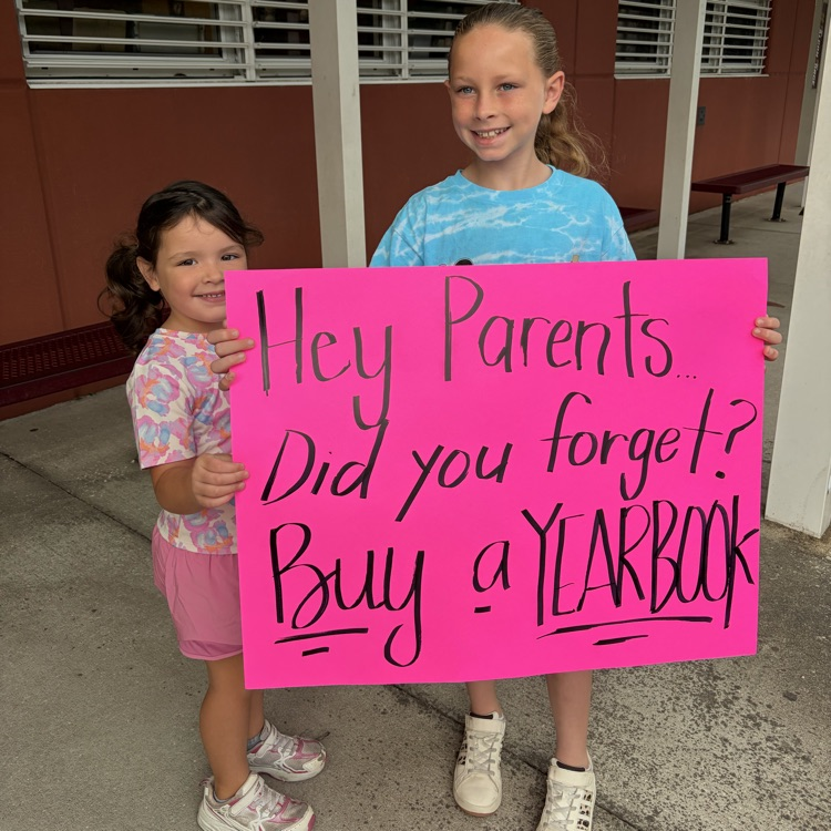 two girls holding a sign