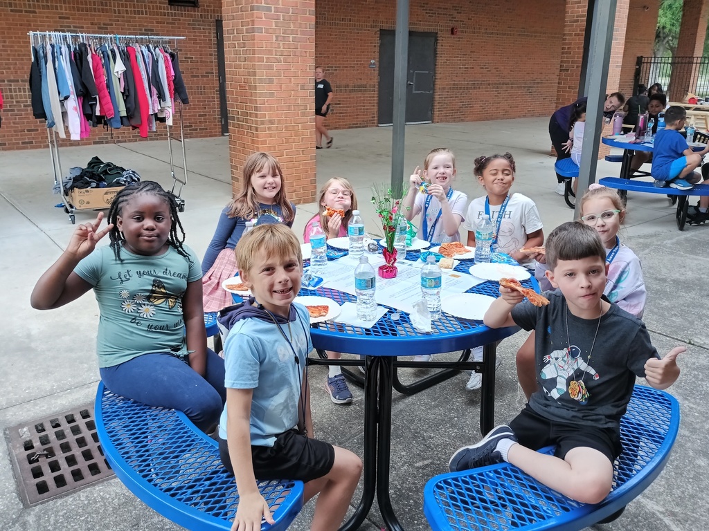 eight students sitting at a picnic table