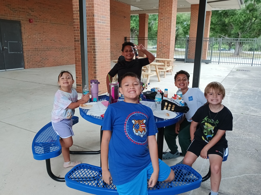 5 students sitting at a picnic table