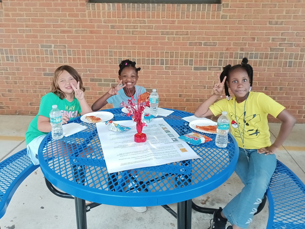 three students at a picnic table