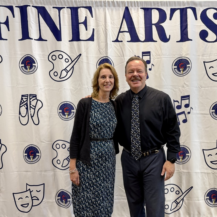 Superintendent Broskie and wife in front of photo backdrop