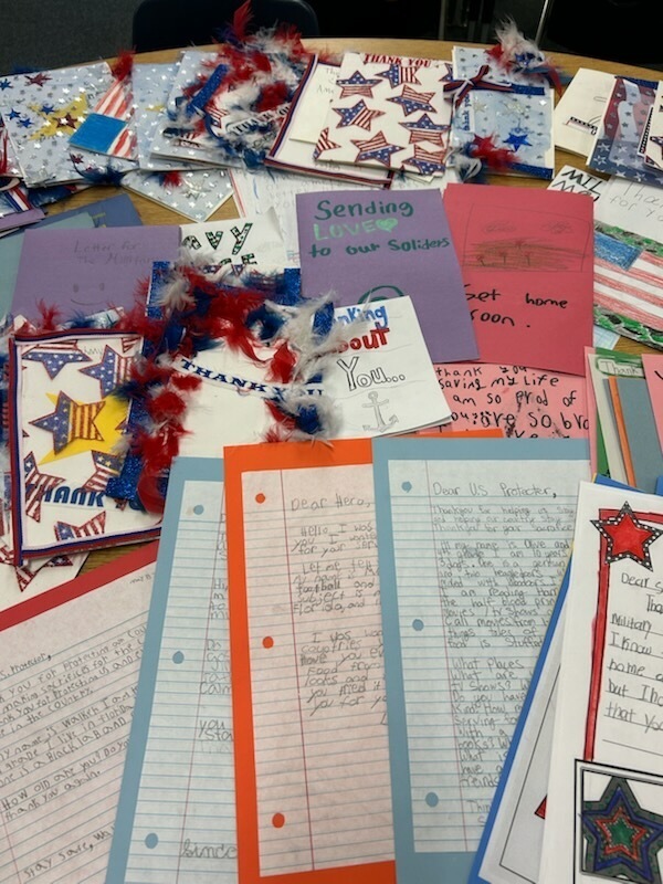 A table displays patriotic cards, letters, and written papers. The materials feature stars and other national symbols.