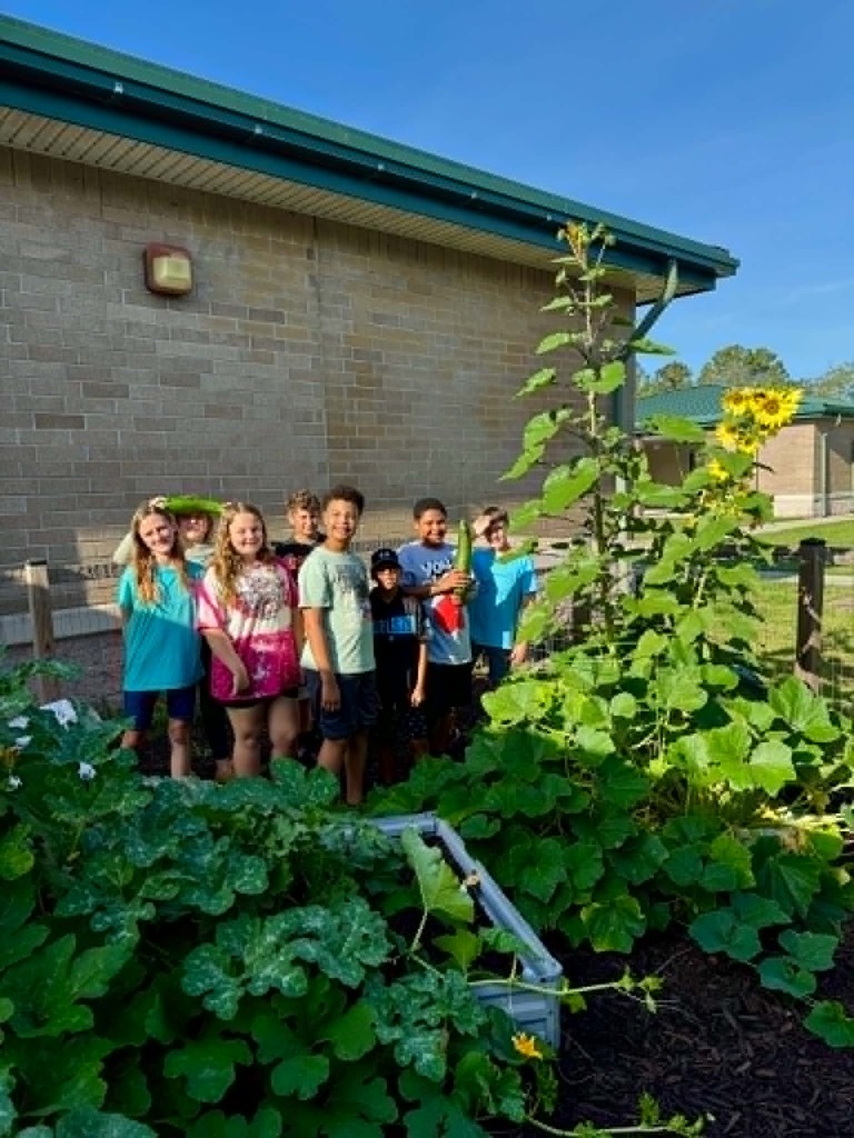 🥒🥗UE Veggie Garden🥗🥒 What a harvest from our UE vegetable garden! They picked some great huge zucchini and lots of lettuce. They gifted the biggest one to Mrs. Dryden as a surprise!