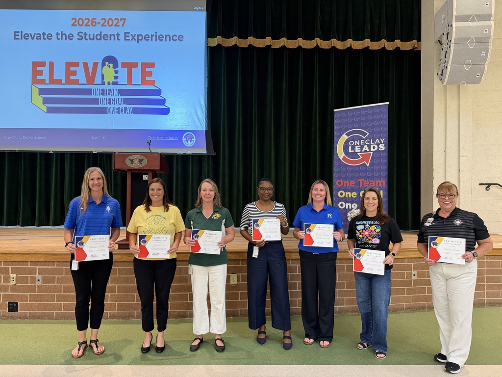 Seven people stand on a stage holding certificates, one reading "ELEVATE." Behind them is a screen with "2026-2027 Elevate the Student Experience."