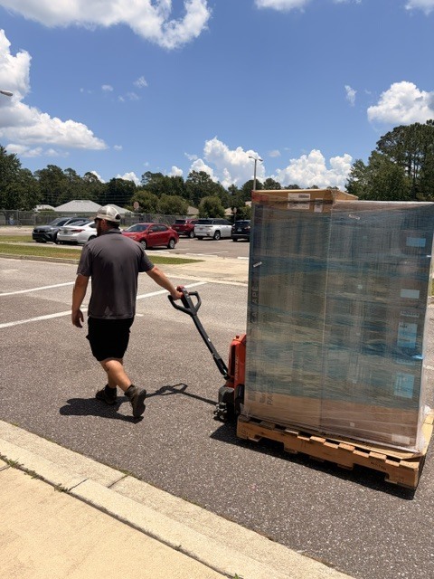 Picture with a man delivering a pallet of boxes.