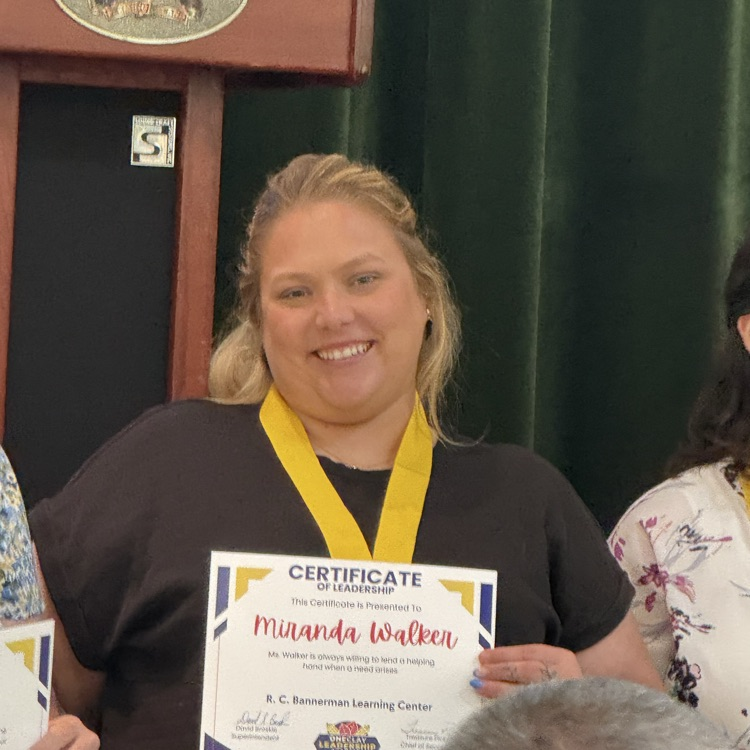 A picture of Miss Walker with her award for leadership