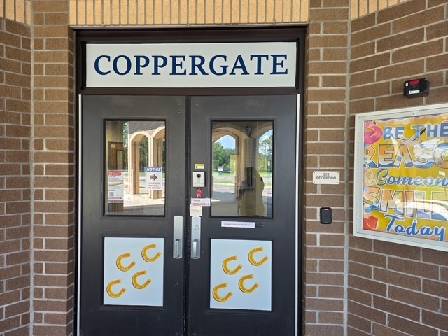 Double black doors with glass panels and "COPPERGATE" sign. Yellow letters on glass. A poster reads "Be the Change Today."