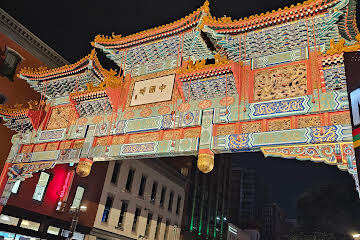 A large, colorful, ornate archway with Chinese characters on a sign in the middle.