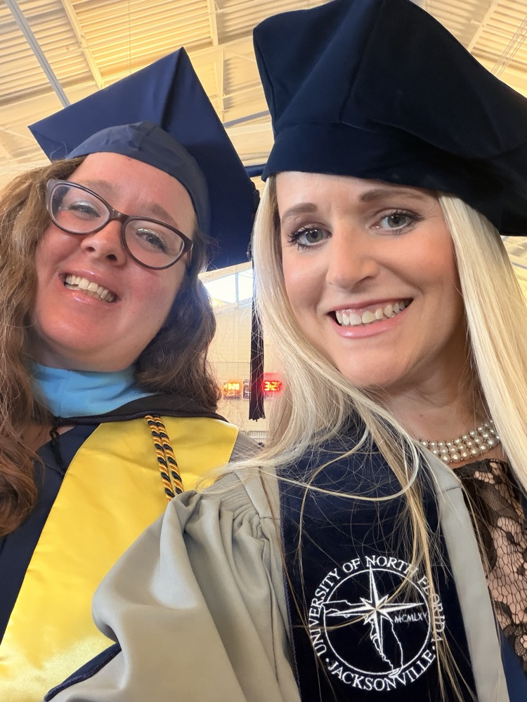 Mrs. Thomas and Principal Metz selfie in their Gray and Navy Blue cap and gown