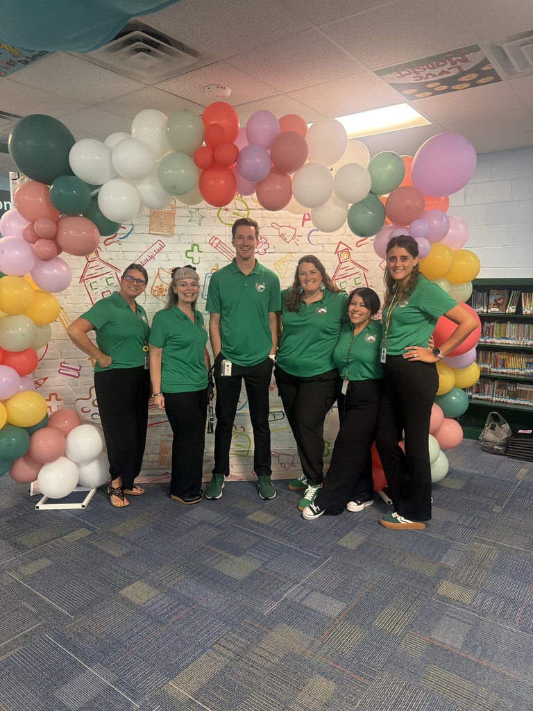 front office staff beneath a balloon arch