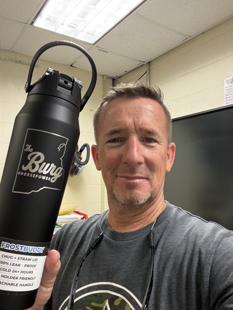 A man holds a large, black, reusable water bottle with the text "The Burg" and a logo.