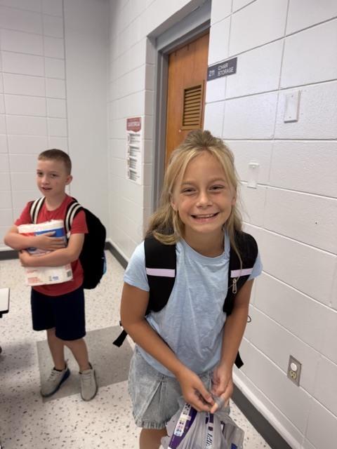 Two kids in a hallway.