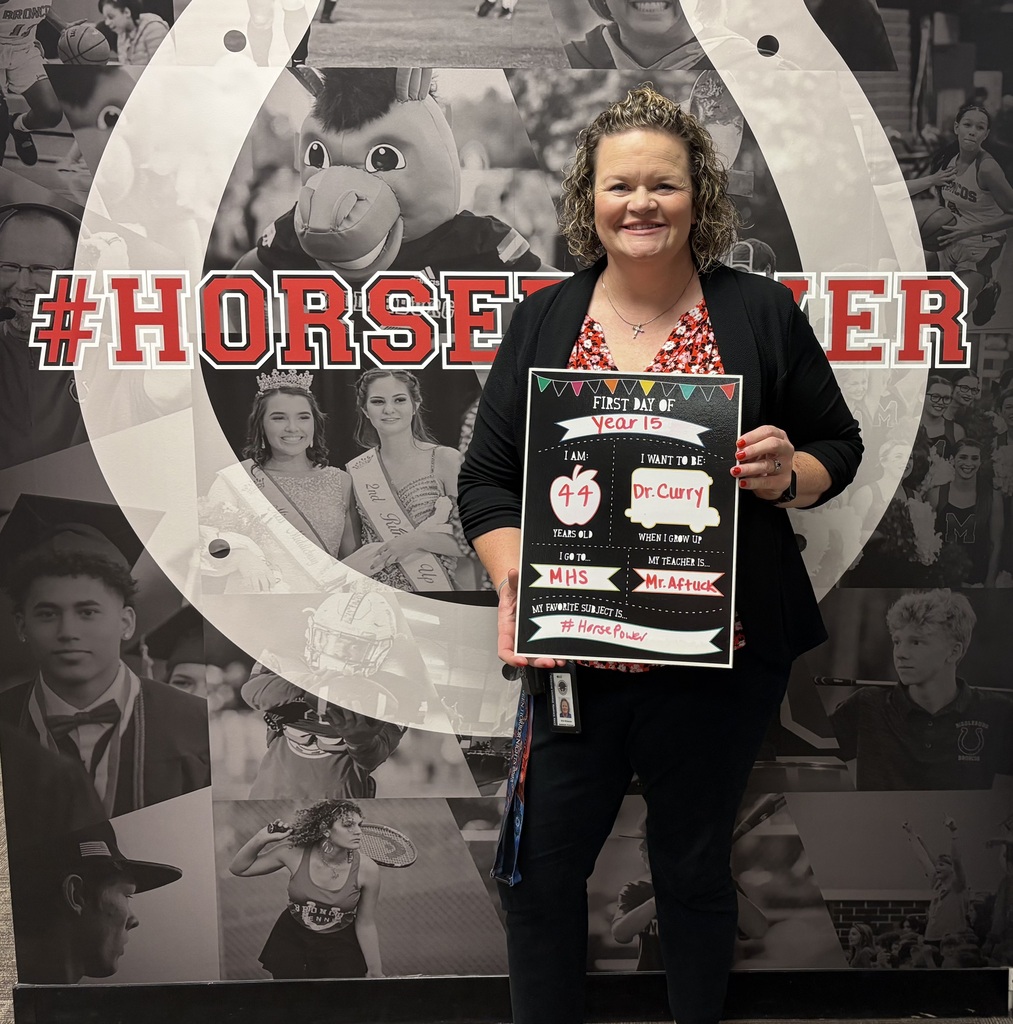 A smiling woman holds a certificate with the text "Year 15" in front of a wall.