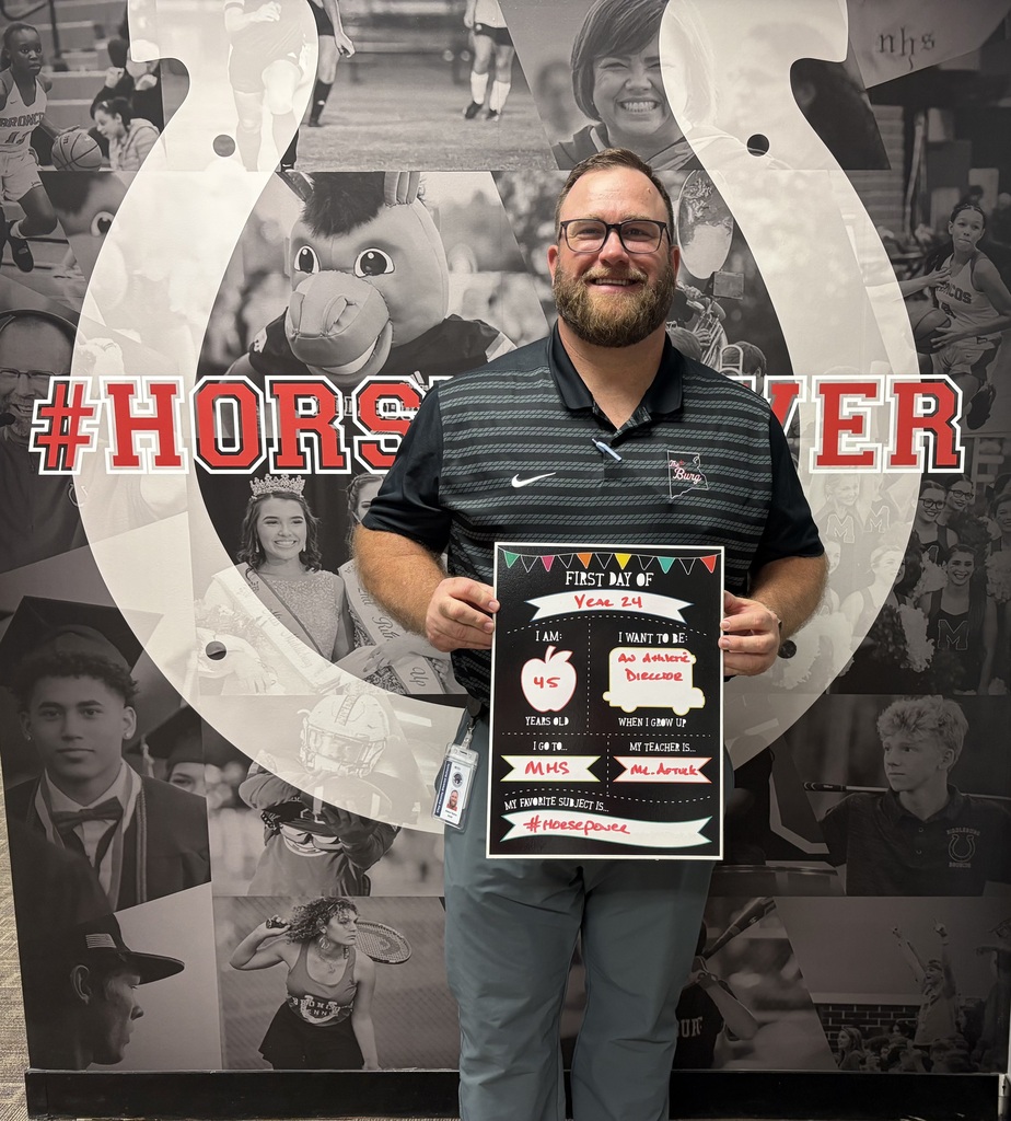 Man with a plaque in front of a collage of school sports team photos and a horse shoe.