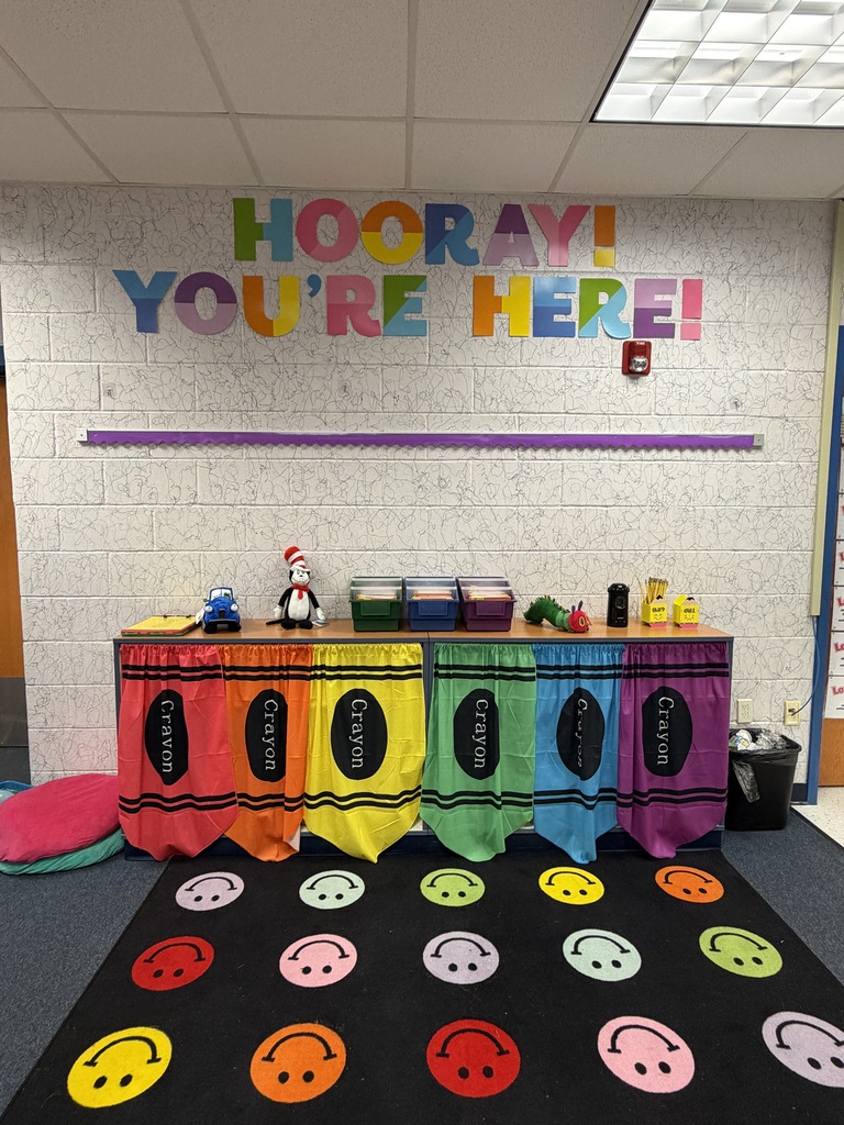 brightly colored classroom decorations. A sign reads "HOORAY! Your'e here!"