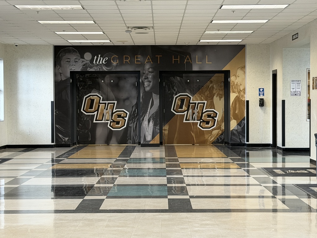 A hallway with tiled floor, large wall mural, and double doors. The mural features a group of people in black and gold.