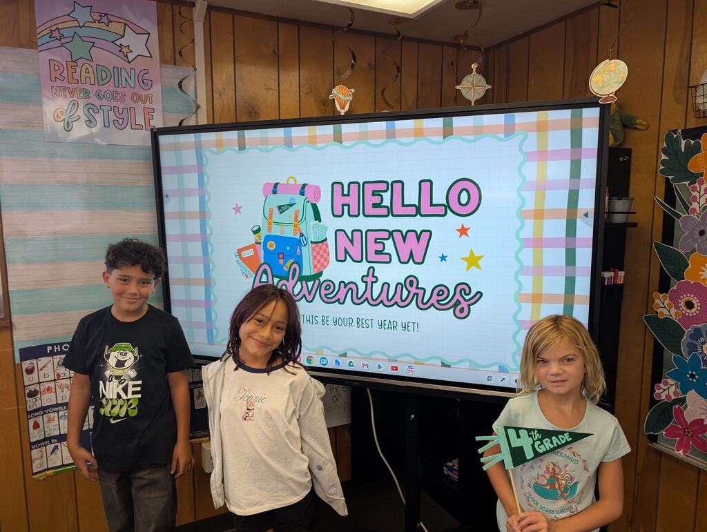 students standing in front of an interactive monitor 