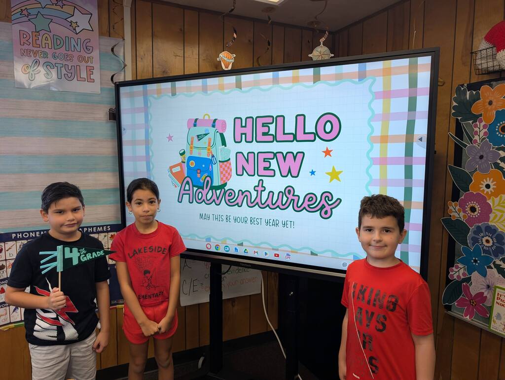 students standing in front of an interactive monitor 