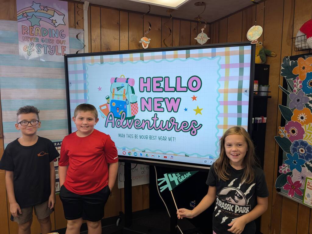 students standing in front of an interactive monitor 
