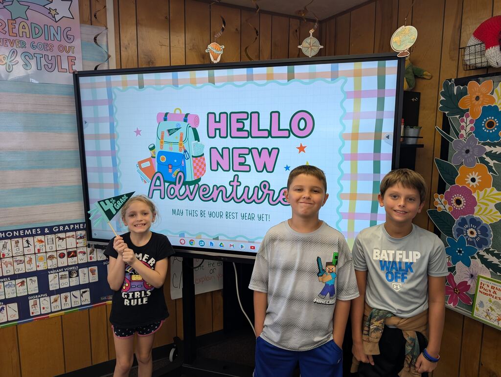 students standing in front of an interactive monitor 