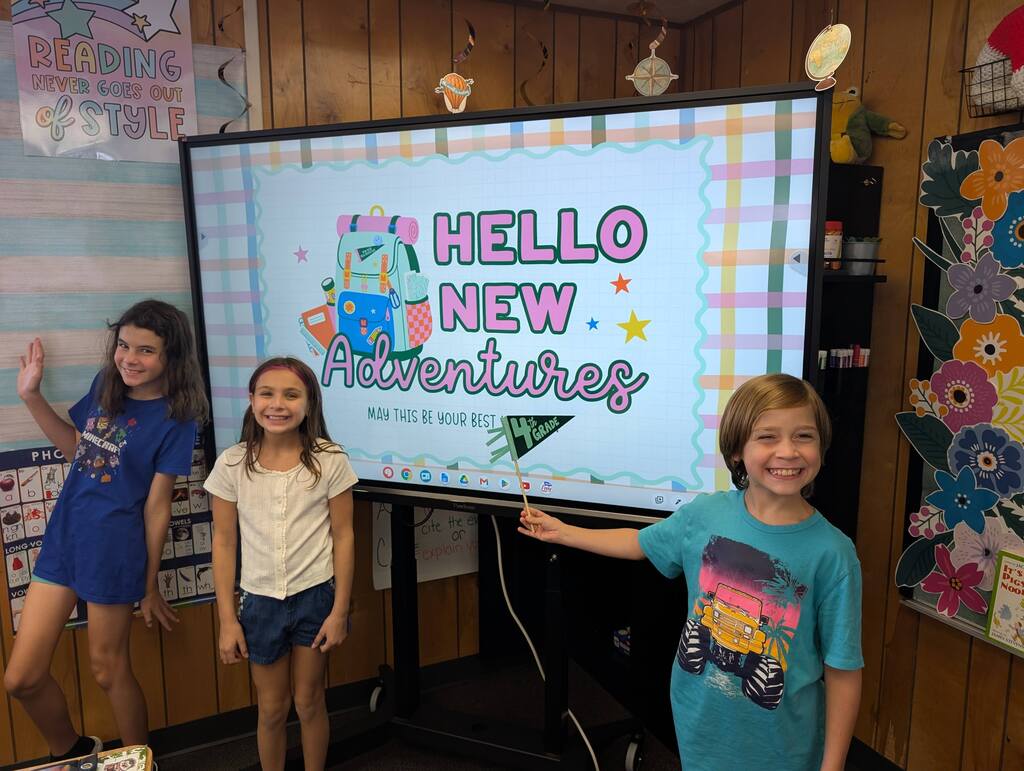 students standing in front of an interactive monitor 