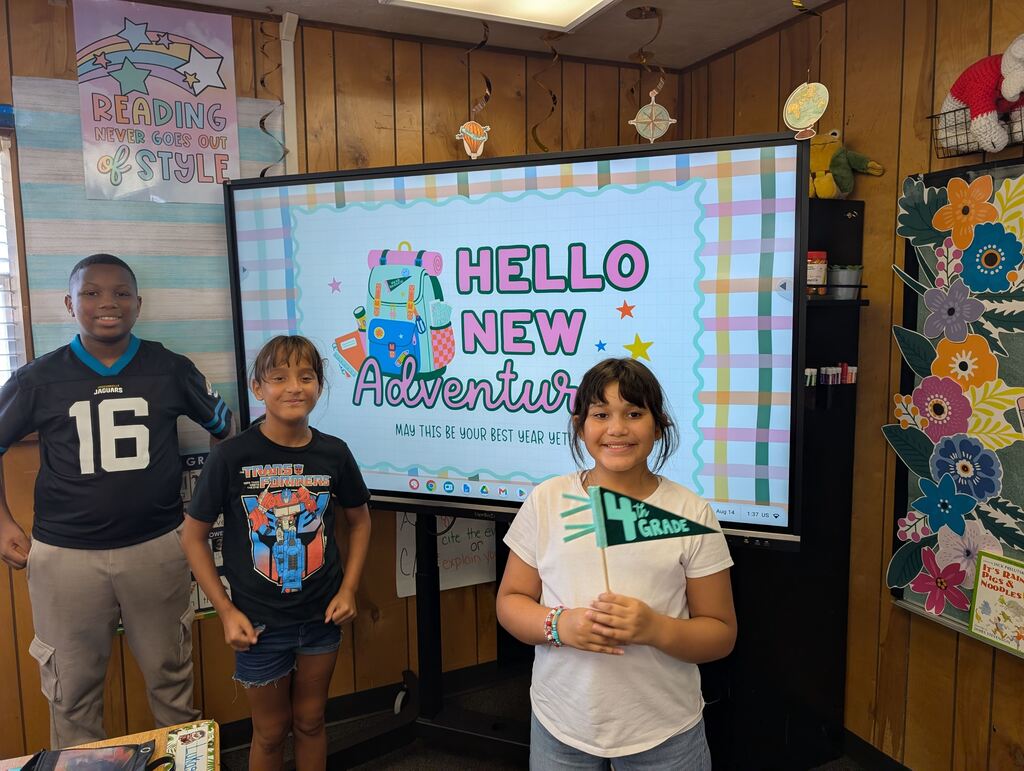 students standing in front of an interactive monitor 