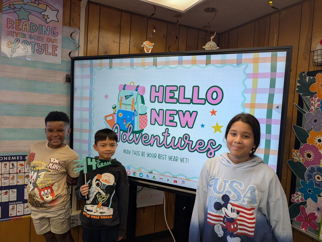 students standing in front of an interactive monitor 