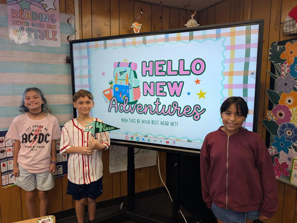 students standing in front of an interactive monitor 