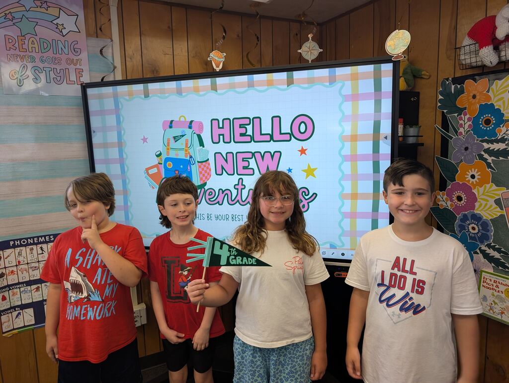 students standing in front of an interactive monitor 